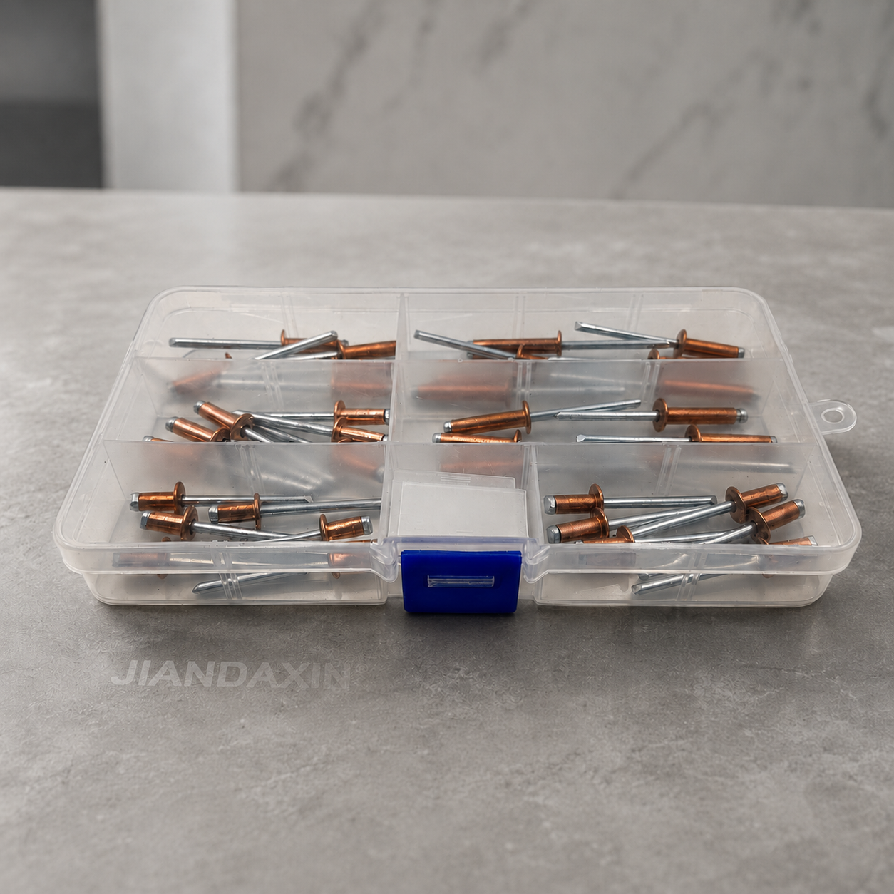 Clear compartment storage boxes filled with copper blind rivets with zinc-plated carbon steel mandrels, shown in a stacked display on a dark premium background.
