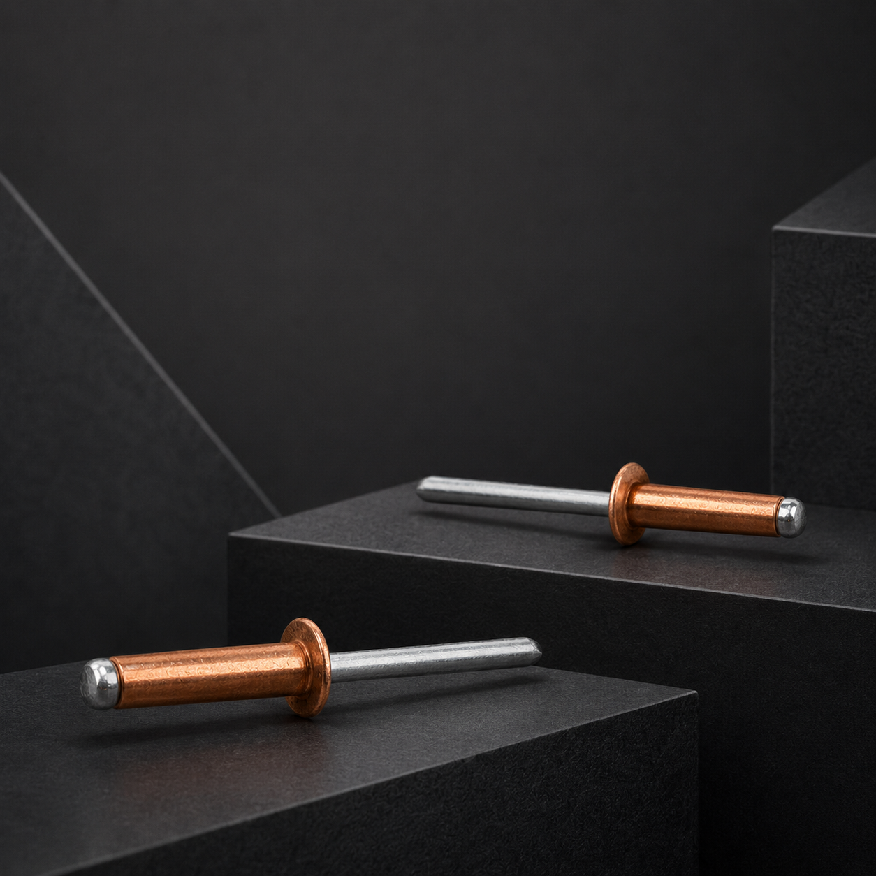 Two red copper open-end blind rivets arranged across layered dark geometric platforms.